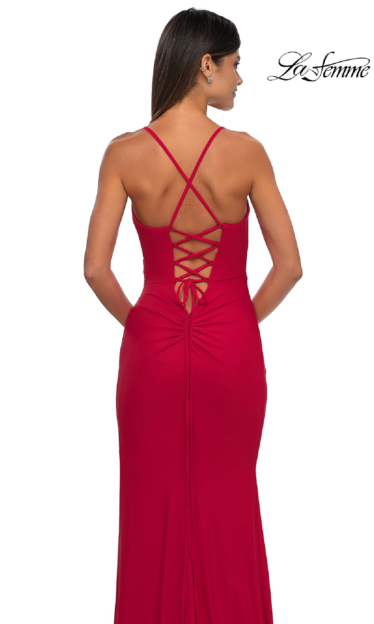 Woman in a sleeveless, red Lace-Up Simple Long Prom Dress: La Femme 33103 with crisscross straps and lace-up back, standing with her back to the camera.